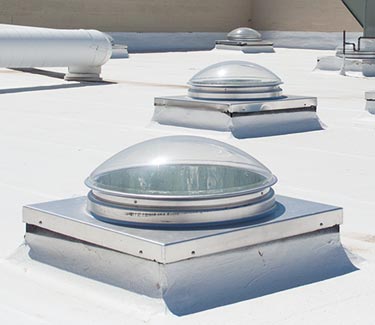 Several Natural Light commercial curb mount tubular skylights on foam roof thumb